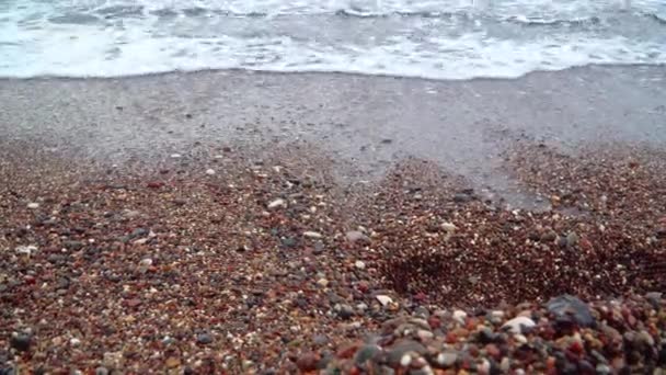 Las olas del mar con espuma lavan la playa de guijarros — Vídeos de Stock