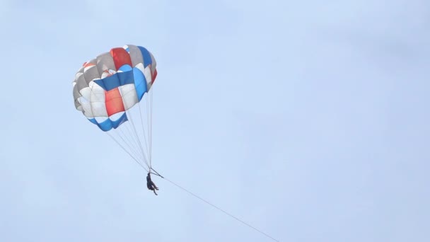 Туристи розважаються у відпустці на морі. Люди літають на парашуті — стокове відео