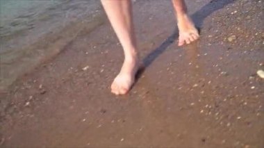 Sahilde yürüyen genç bir kızın ayakları. Sahilde sevgilim. Bacakları yakın çekim. stok video