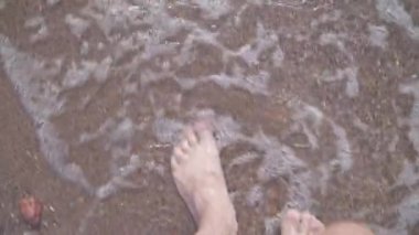 Adam sahilde yalınayak yürüyor. Bacaklarını kapat. stok video