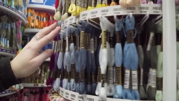 Minsk Belarus november 2019. Vrouw kiest draad voor naaien in de supermarkt — Stockvideo
