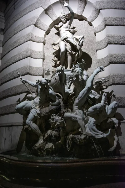 Female sculpture on the michaelerplatz Fountain in Hofburg at night. Vienna