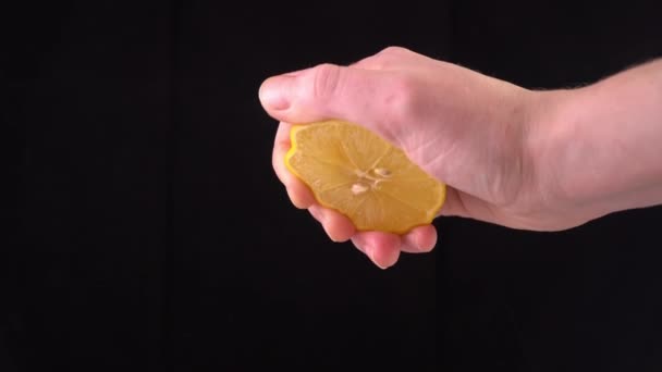 Close-up of a lemon. hand squeezes of lemon juice — Stock Video