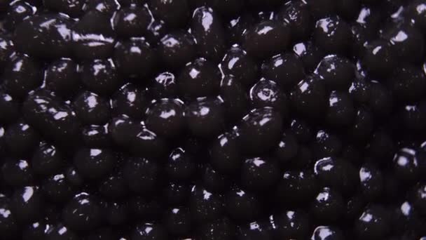 Hintergrund von schwarzem natürlichen Kaviar in Nahaufnahme — Stockvideo