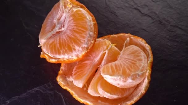 Rotating tangerines close up on a dark background — Stok Video