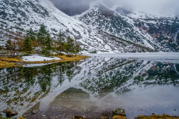 Hermosas montañas nevadas reflejadas en un lago de montaña Morsko oko en las montañas Tatra, Polonia — Foto de Stock