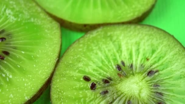 Rebanada de kiwi fresco jugoso gira sobre la mesa en primer plano — Vídeos de Stock