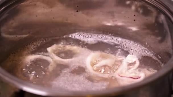 Nahaufnahme von kochendem Wasser mit in Ringe geschnittenen Tintenfischen — Stockvideo