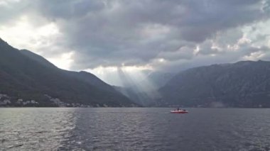Kotor Körfezi 'nde günbatımı. Bulutların arasından ışık