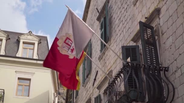 Kotor, Černá Hora. Vlajka Kotoru a Černé Hory na fasádě staré budovy — Stock video