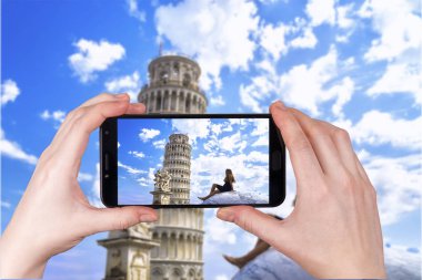 İtalya 'daki Eğik Kule' ye hayran olan genç bir kız. Telefonda çekilmiş bir fotoğraf.
