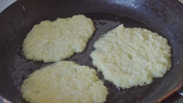 Close-up van gebakken aardappelpannenkoeken in olie in een koekenpan. Termijn — Stockvideo