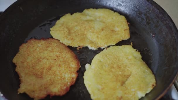 Close-up van gebakken aardappelpannenkoeken in olie in een koekenpan — Stockvideo