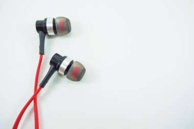 Beyaz zemin üzerine kırmızı kulaklık lay.