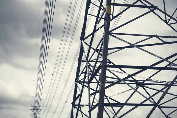 Pali di elettricità nel cielo buio nuvoloso . — Foto Stock