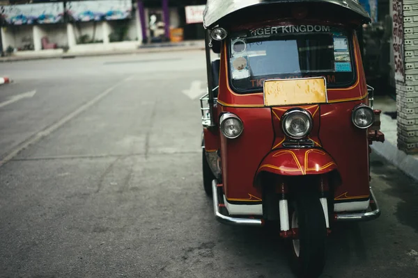 Triciclo rojo estacionado en la calle . — Foto de Stock