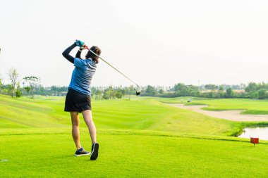 Yalnız kız yeşil golf sahasında golf