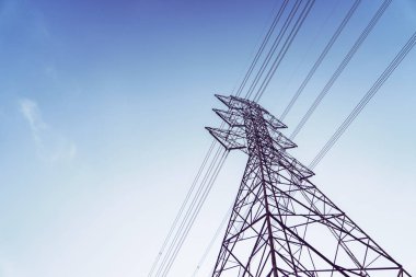 Yüksek gerilim kuleleri parlak sabah gökyüzünde.