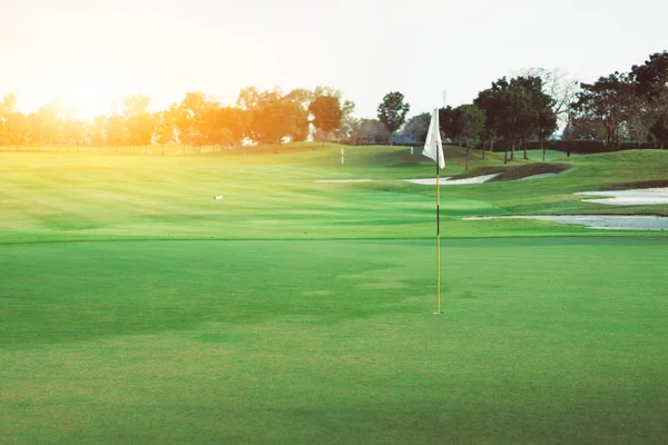 Pole golfowe w godzinach porannych w zielony trawnik. — Zdjęcie stockowe