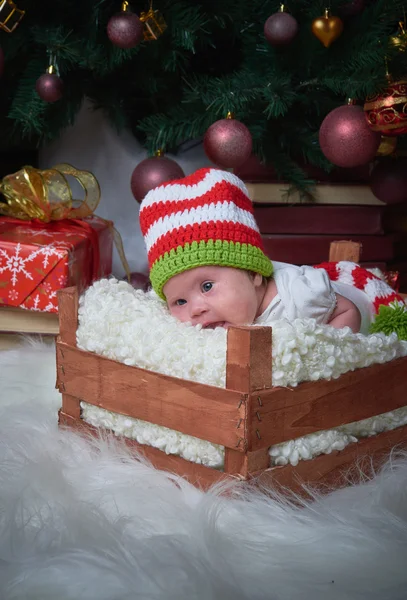 Weihnachtsbaby in der Schachtel unter dem Weihnachtsbaum, frohes neues Jahr, frohe Weihnachten, Geschenke, rotes Weihnachtsspielzeug. — Stockfoto