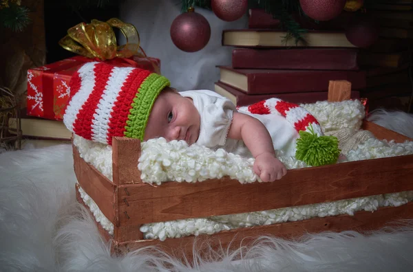 Dziecko Boże Narodzenie w polu leżącego pod choinkę, szczęśliwego nowego roku, Wesołych Świąt, prezenty, czerwony Boże Narodzenie zabawki. — Zdjęcie stockowe