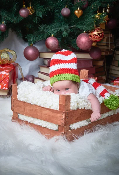 Weihnachtsbaby in der Schachtel unter dem Weihnachtsbaum, frohes neues Jahr, frohe Weihnachten, Geschenke, rotes Weihnachtsspielzeug. — Stockfoto