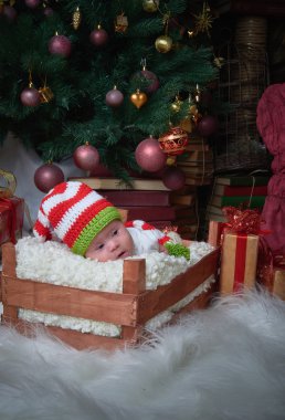 Noel bebek yalan Noel ağacı, mutlu yıllar, mutlu Noeller, hediyeler, kırmızı Noel oyuncaklar altında kutusunda.