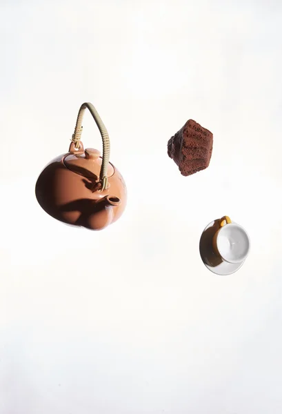 Fliegende Teekanne, Kuchen, Tasse auf weißem Hintergrund. — Stockfoto