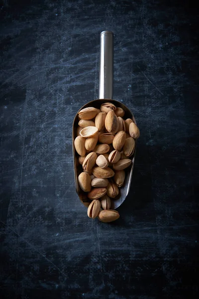 Pistachios over dark background. Food background with copyspace.