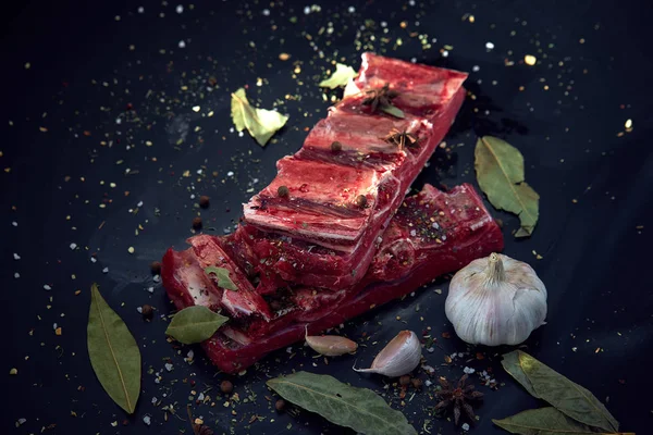 Frisches rohes Fleisch. Gewürze und Knoblauch. auf schwarzem Hintergrund. Ansicht von oben, Kopierraum — Stockfoto