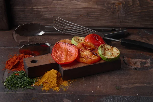 Izgara sebze ve baharat karanlık bir arka plan üzerinde çeşitli.