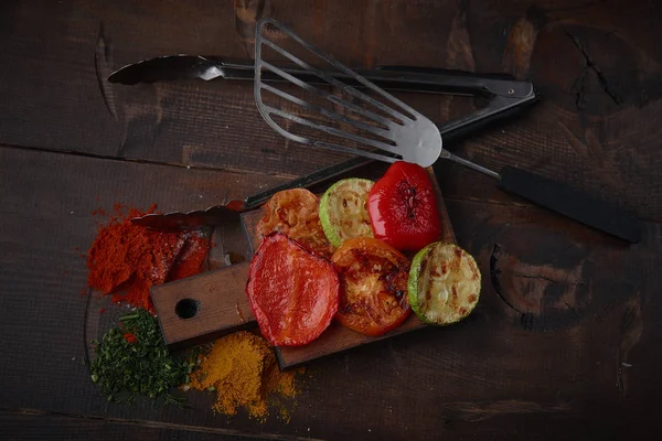 Izgara sebze ve baharat karanlık bir arka plan üzerinde çeşitli.