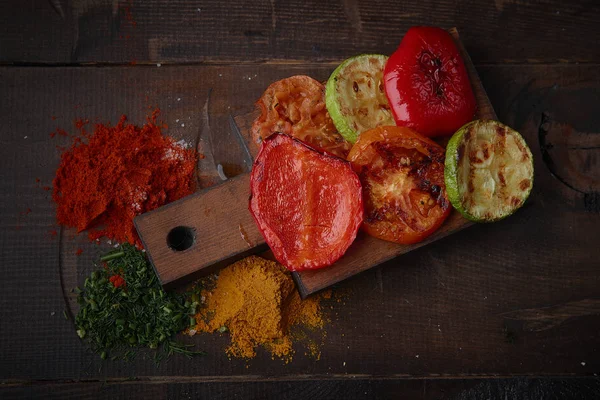 Izgara sebze ve baharat karanlık bir arka plan üzerinde çeşitli.