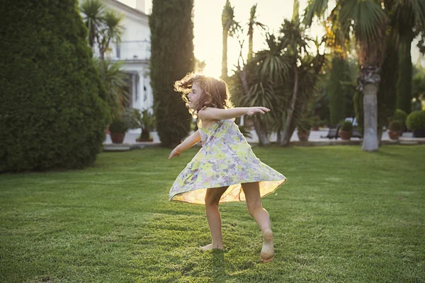 Mädchen dreht sich im Garten herum — Stockfoto