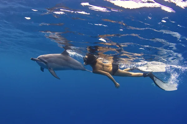 Femme nageant avec dauphin — Photo
