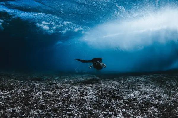 Feminino nadando sob ondas — Fotografia de Stock