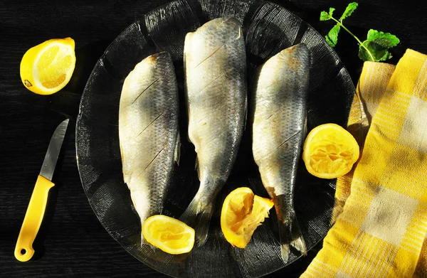 Fishes on plate with lemons — Stock Photo, Image