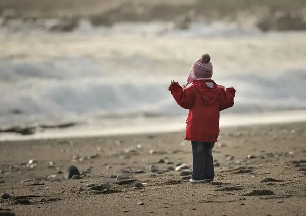 Girl on beach looking at sea — Stock Photo, Image