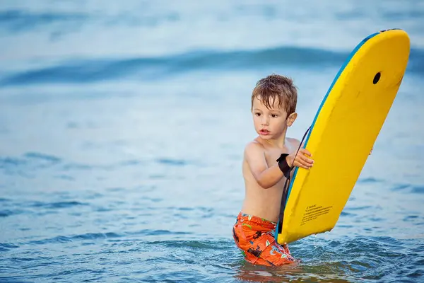 서핑 보드와 함께 바다에 서 있는 소년 — 스톡 사진