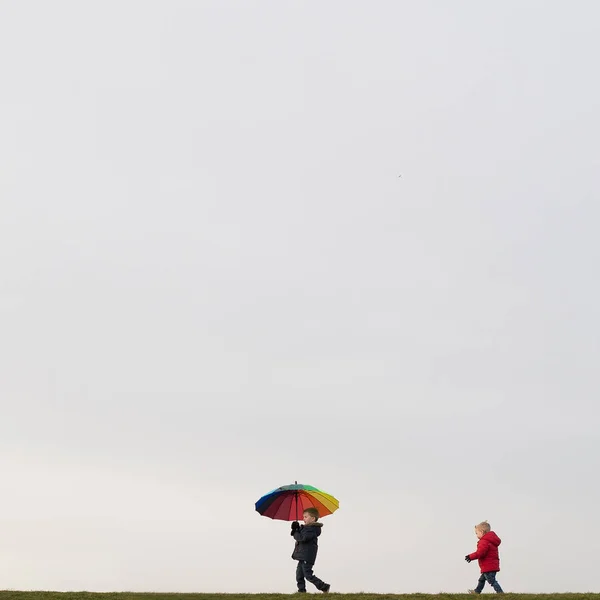 Ragazzi che camminano, con l'ombrello in mano — Foto Stock