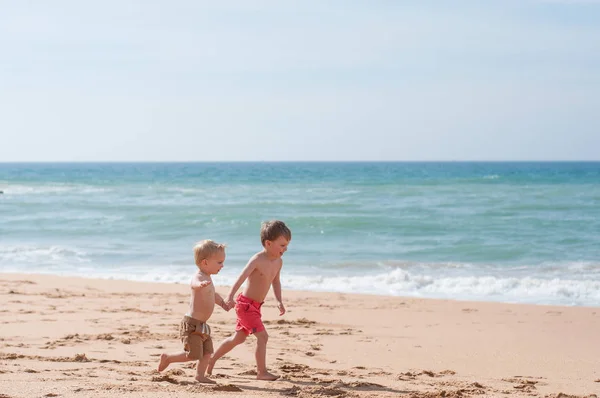 Dua anak laki-laki berjalan di pantai — Stok Foto