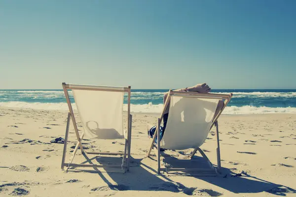 放松的人坐在躺椅上在海滩上 — 图库照片