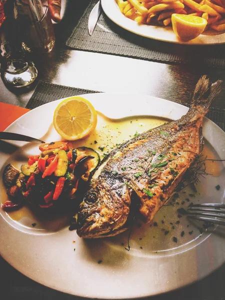 Риби на плиті, з овочами — стокове фото