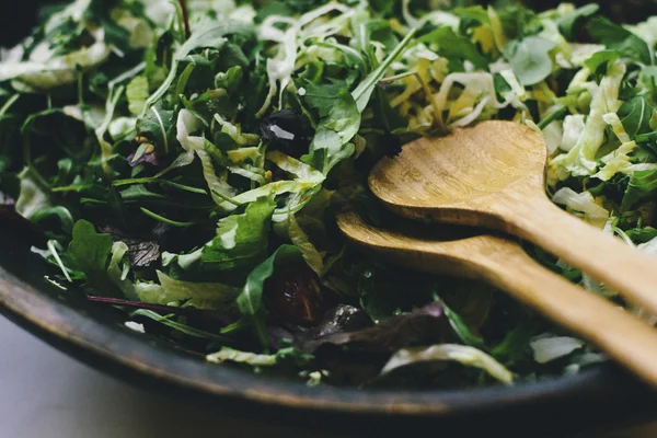 Zwei Holzlöffel in Schüssel mit Salat — Stockfoto