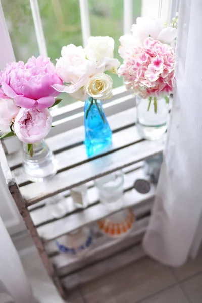 Fleurs dans des vases en verre sur étagère — Photo de stock