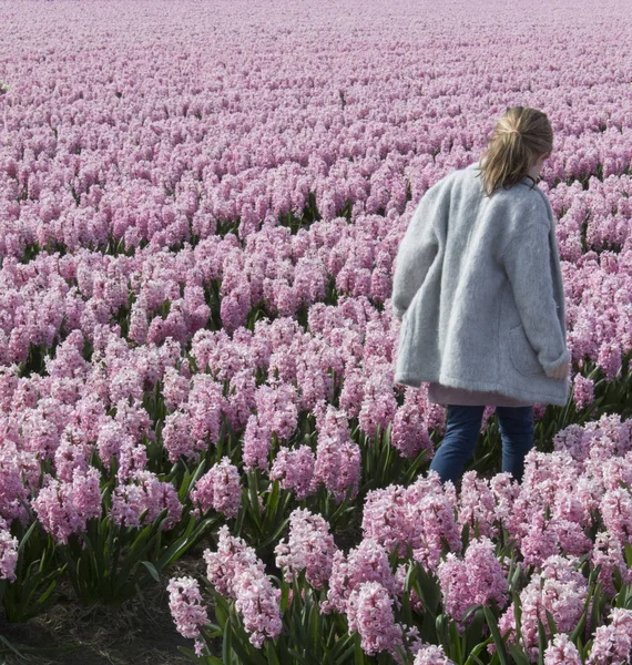 Chica caminando a través de un campo - foto de stock