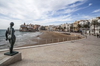  Deniz promenade, heykel, plaj ve köy görünümü, Sitges, il Barcelona, İspanya.