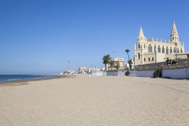Beach and Sanctuary of Nuestra Senora de la Regla, maritime promenade of Chipiona, Andalucia. clipart