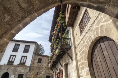 Santillana del Mar, il Santander, Cantabria, İspanya Turizm köyde köy Caddesi, tipik evleri cephe ve taş kemer.