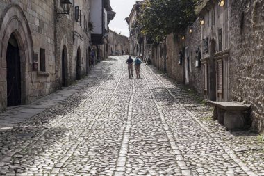 Typical street in touristic village of Santillana del Mar, province Santander, Cantabria, Spain. clipart